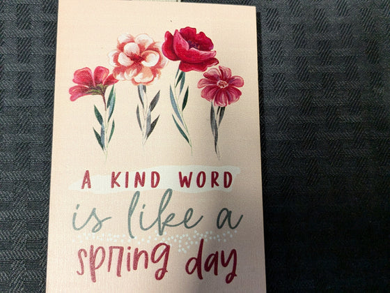 "A kind word is like a spring day" painted block