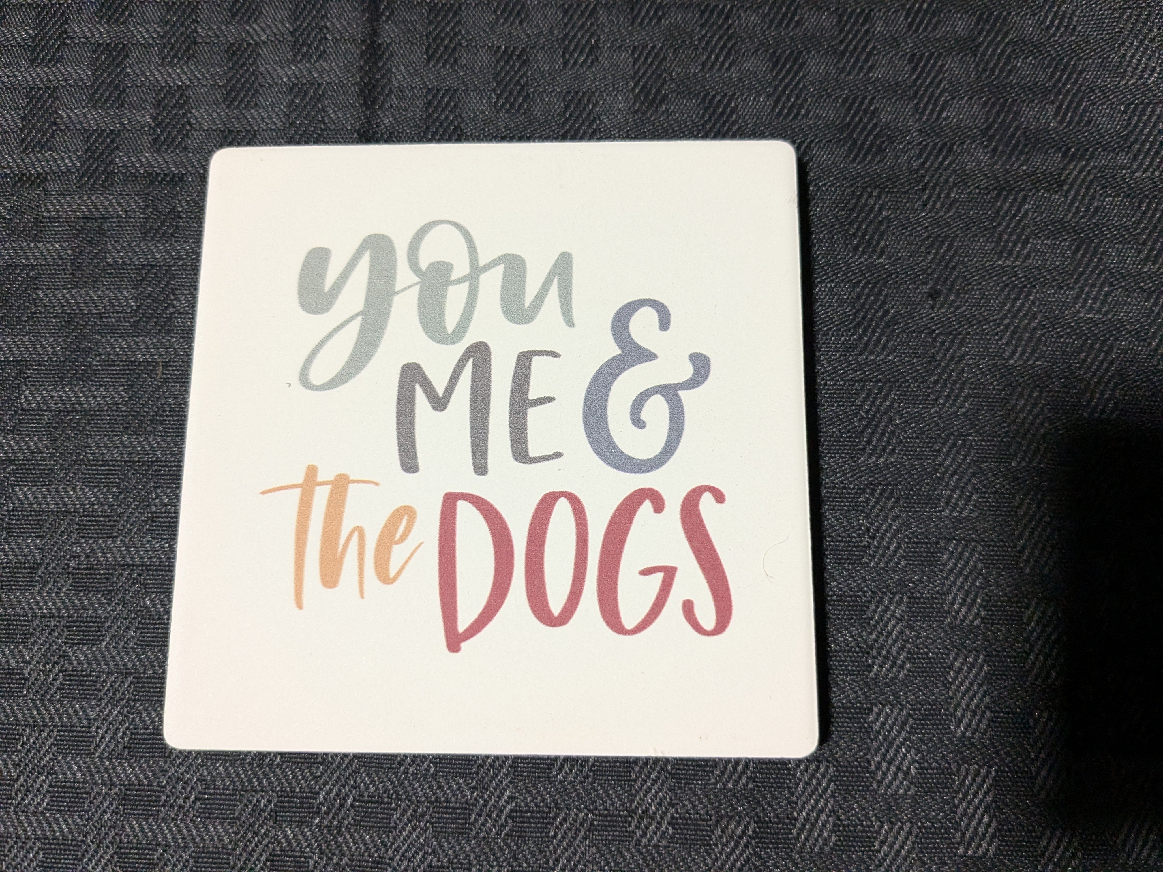 You Me & the Dogs' ceramic coaster – a charming and durable coaster featuring a heartfelt message perfect for dog lovers. Ideal for protecting surfaces while adding a touch of personality to your home decor.